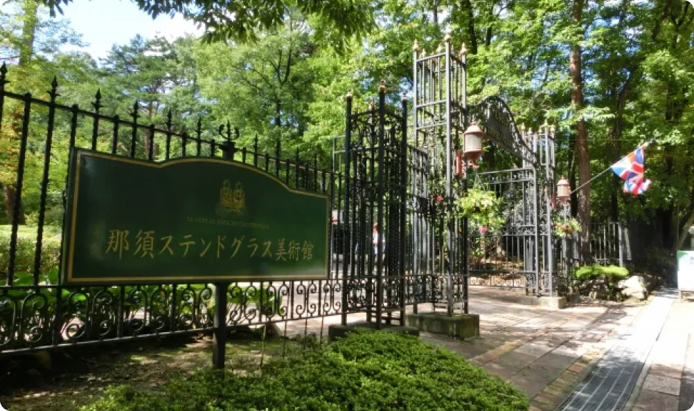 那須ステンドグラス美術館の門と緑の並木道